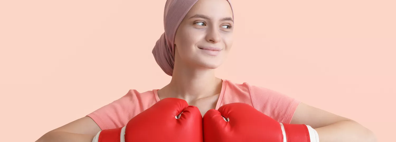 adolescente portant des gants de boxe rouge et un foulard rose sur sa tête